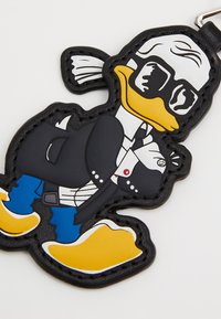 Rubber keychain featuring a cartoon duck in a black suit and glasses, with yellow beak and feet, and blue pants. Black outline and stitching.