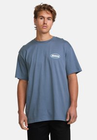 Blå bomulds T-shirt med rund halsudskæring og korte ærmer. Har et hvidt oval logo med "Billabong" tekst på brystet.
