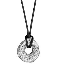 Silverfärgad rund hänge med en texturerad yta, hängande på ett svart läderband. Har ett centralt hål och en robust design.