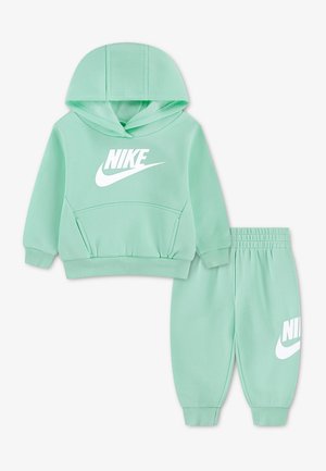 Φούτερ Nike για νήπια σε μέντα πράσινο με μπροστινή τσέπη και ταιριαστό παντελόνι, και τα δύο με λευκό λογότυπο Nike.
