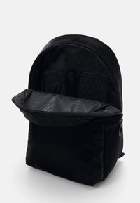 Zaino in tessuto nero con texture liscia, parte superiore arrotondata, chiusura con zip e rivestimento interno a fantasia. L'apertura superiore rivela un ampio scomparto.