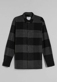 Skjorta med knäppning i svart och grå rutmönster, med långa ärmar, krage och två bröstfickor. Tåligt tyg med en mjuk yta.