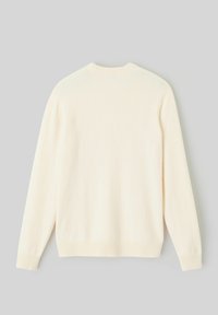 Pull créme de couleur fabriqué en tissu doux, avec un col rond, des manches longues et des bords côtes au bas et aux poignets. Design simple et uni.