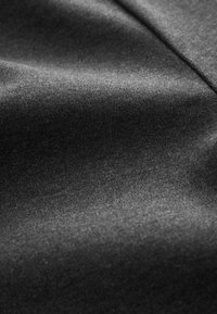 Schwarzer Stoff mit einer glatten, leicht glänzenden Textur. Er hat einen subtilen Glanz, eine feine Webart und ein minimales Muster, und vermittelt ein leichtes Gefühl.