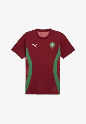 Bordo futbola krekls ar zaļām sānu paneļiem, Puma logo uz krūtīm un Marokas emblēma. Izgatavots no elpojoša auduma ar teksturētu apdari.
