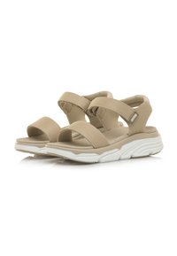 Sandali beige con spesse cinturini regolabili, punta aperta e materiale texturizzato. Suola imbottita con un design ondulato e accenti bianchi.
