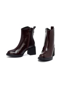 Stivali alla caviglia in pelle verniciata bordeaux con tacco a blocco, zip frontale e finitura testurizzata. Caratterizzati da una punta arrotondata e un design all'altezza della caviglia.