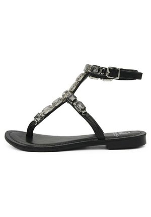 Infradito neri piatti con design a T-strap. La parte superiore presenta dettagli trasparenti e sfaccettati, e una cinturino alla caviglia con fibbia. Suola liscia.