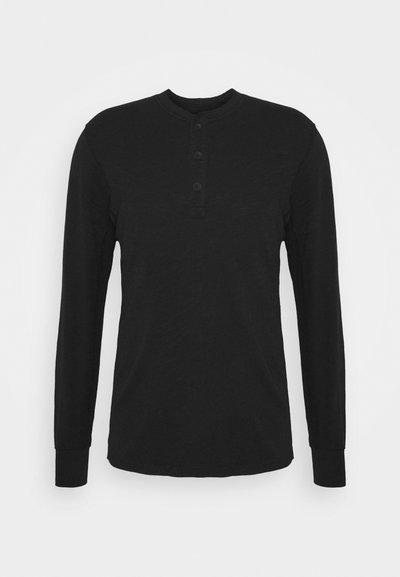 Sort langærmet skjorte med rund halsudskæring, tre-knaps måtte og tætsiddende ærmer. Lavet af blød stof med en glat tekstur.