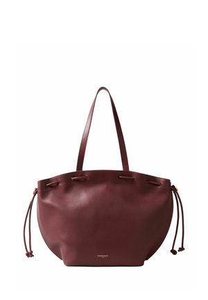 Borsa tote in pelle marrone con lunghe spalline, lati con coulisse e piccolo logo dorato vicino al centro inferiore.
