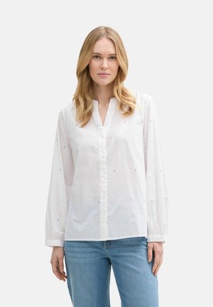 Chemise blanche à manches longues avec un col en V et fermeture à boutons, ornée de petites rayures verticales multicolores.