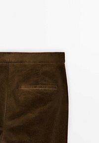 Pantalons en velours côtelé marron avec une texture lisse, dotés d'une poche arrière et d'une coupe droite, présentés sur un fond blanc.