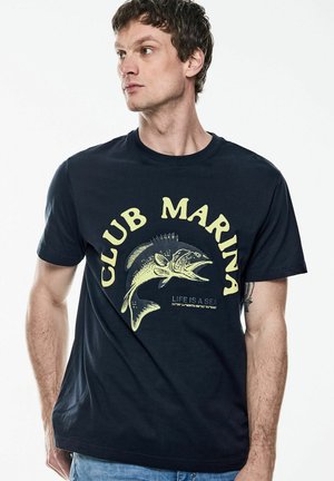 Navy blue cotton t-shirt featuring yellow text "CLUB MARINA" and fish graphic with coordinates. Crew neck and short sleeves.