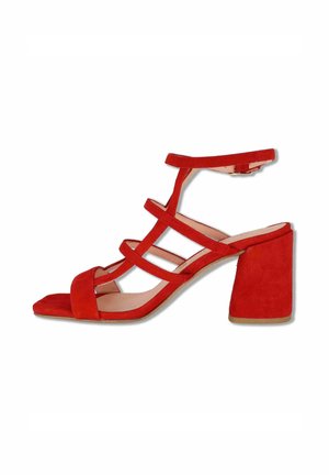 Sandalo aperto in camoscio rosso con tacco a blocco e tre sottili cinturini sul collo del piede, oltre a cinturino alla caviglia con chiusura a fibbia.