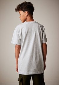 Gray cotton t-shirt with a crew neck, short sleeves, and a relaxed fit, viewed from the back. Simple design without patterns or graphics.