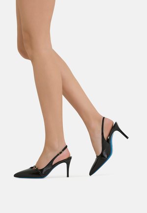 Dei tacchi a stivaletto in vernice nera con punta affusolata, dotati di un accento con fibbia dorata e una suola blu. Design del tacco a stiletto.