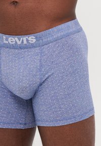 Plave Levi's bokserice s točkastim uzorkom. Elastični pojas s logotipom, glatka tekstura i prilagođen dizajn.