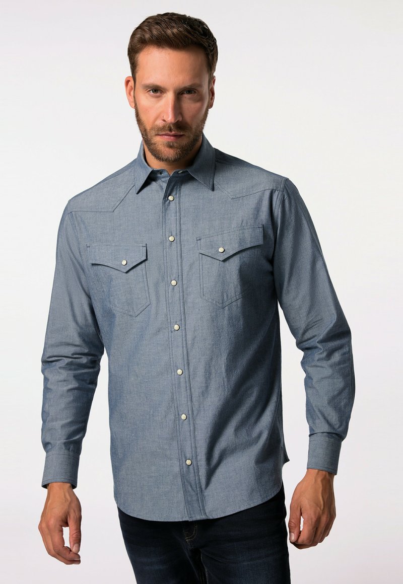 Dlouhá denimová košile, světle modrá, zapínání na knoflíky s dvěma náprsními kapsami, špičatý límec a jemná textura. Obsahuje kovové cvokové knoflíky.