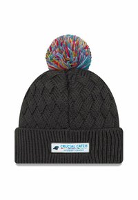 Berretto lavorato a maglia nero con un motivo testurizzato, dotato di un pompon multicolore in cima e di un'etichetta bianca con la scritta "CRUCIAL CATCH - INTERCEPT CANCER."