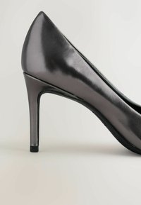 Glänzender schwarzer High-Heel-Pumps mit spitzem Zeh und schlankem Stiletto-Absatz. Glatte Ledertextur mit schlanker Silhouette.
