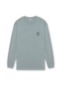 Camisa de manga larga azul claro, hecha de tejido suave, con un escote redondeado y un pequeño logotipo gráfico en el lado izquierdo del pecho.