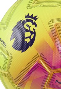 Keltainen ja vaaleanpunainen Valioliigan jalkapallo mustalla kruunupurjekuvalla ja geometrisilla yksityiskohdilla.