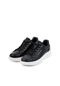 Para czarnych skórzanych sneakersów z białymi podeszwami, czarnymi sznurowadłami i brandingiem "PAKOLLORENTE" po boku.