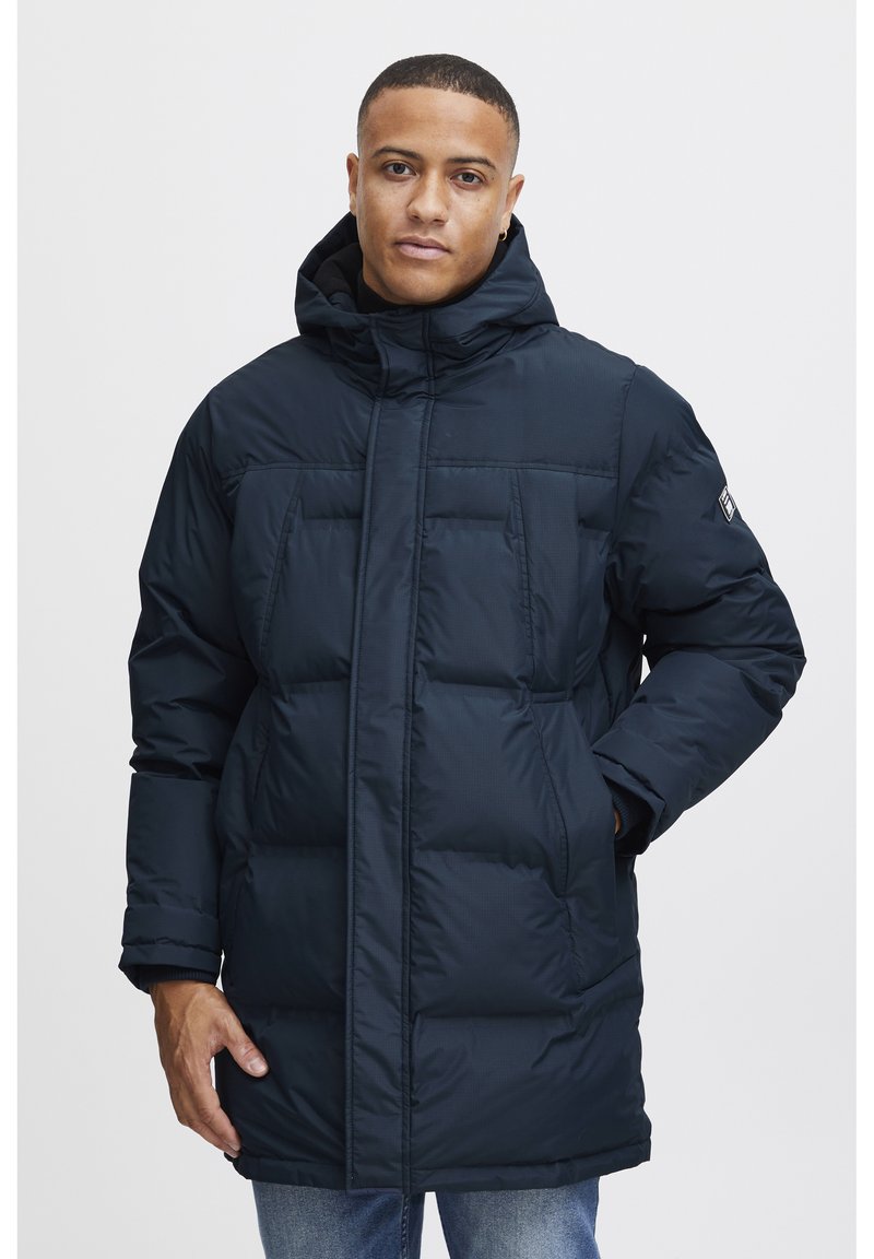 Navy padded coat with a high collar and adjustable hood. Two front pockets and elastic cuffs for warmth. Features a smooth, shiny texture.