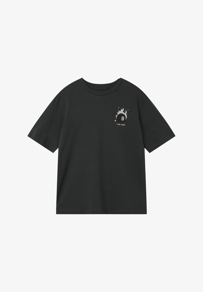 T-shirt noir à manches courtes avec un petit visuel blanc d'une boule huit en flammes et le texte « TAKING CHANCES » sur la poitrine gauche.