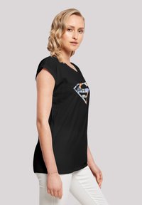 Black t-shirt with a short-sleeve design, featuring a multicolored "S" logo at the front. Smooth texture, casual fit.