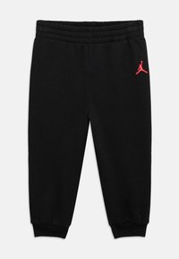 Μαύρο βαμβακερό παντελόνι jogger με ελαστική μέση και μανσέτες με ριμπ ύφανση, με κόκκινο λογότυπο Jordan στην αριστερή μηρή.