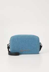 Blue denim crossbody bag with a rectangular shape, featuring black hardware, a leather strap, and silver logo detailing on the front.
