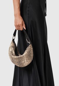 Käsilaukku hobo-tyylillä, jossa on teksturoitu, käärmeennahkakuosisurface vaaleanruskeassa ja ruskeassa, mustalla nahkahandlella ja hopeanvärisillä yksityiskohdilla.