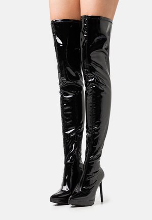 Botas negras hasta el muslo, hechas de cuero sintético brillante, con punta afilada y tacón alto de aguja, con un diseño elegante y ceñido.