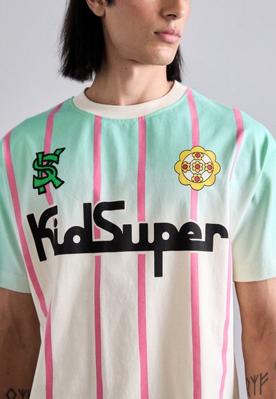 Short-sleeve t-shirt in mint with pink stripes, featuring "KidSuper" logo in black, green dollar sign, and a yellow floral graphic.