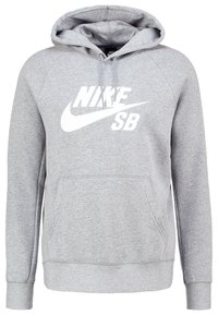 Sudadera gris de material suave, con un bolsillo tipo canguro, capucha con cordones y un llamativo logo blanco "NIKE SB" en el frente.