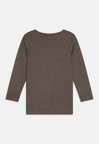 Brun ribbet langermet topp med rund halslinning. Laget av mykt stoff med tekstur. Har rett snitt og tettsittende ermer.