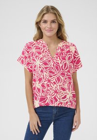 Blusa a maniche corte con un motivo floreale rosa e crema, scollatura a V e vestibilità rilassata, realizzata in tessuto leggero.