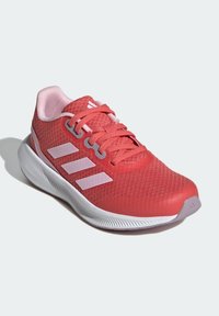 Czerwony but sportowy z oddychającą cholewką z siateczki, różowymi akcentami, trzema białymi paskami, amortyzowaną podeszwą i teksturowaną gumową podeszwą zewnętrzną.