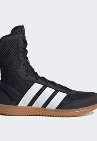 Sort mesh atletisk sko med hvid tre-stribe design, snørebånd foran og gummisål. Har en høj krave for ankelstøtte.