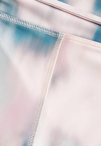 Badestof med en gradient tie-dye mønster i pink og blå, med en glat tekstur og flad syning detaljer.