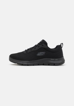 Black athletic shoe with a mesh upper, round toe, lace-up design, and textured sole. Features a logo on the side and pull tab at the heel.
