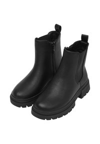 Un paio di stivali alla caviglia in pelle nera con suole spesse, cerniera laterale, pannelli elastici e linguette posteriori.