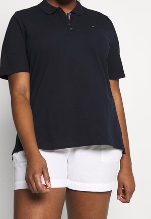 Marineblå kortærmet polo skjorte lavet af bomuld, med krave, tre knapper og et lille logo. Kombination med hvide shorts.