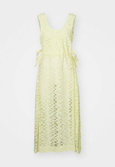 Robe jaune avec un motif à carreaux, décolleté en scoop et liens à la taille. Le tissu semble léger et semi-transparent. Silhouette longue et fluide.