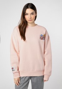 Helles rosa Sweatshirt mit Rundhalsausschnitt, fallenden Schultern und einem bunten gestickten Grafikdesign auf der Brust. Weicher, strukturierter Stoff.