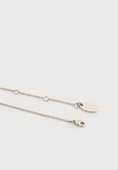 Ασημένιο κολιέ αλυσίδα με κούμπωμα λάμπρα και οβάλ ταμπελάκι με χαραγμένο το "Vivienne Westwood" σε λευκό φόντο.