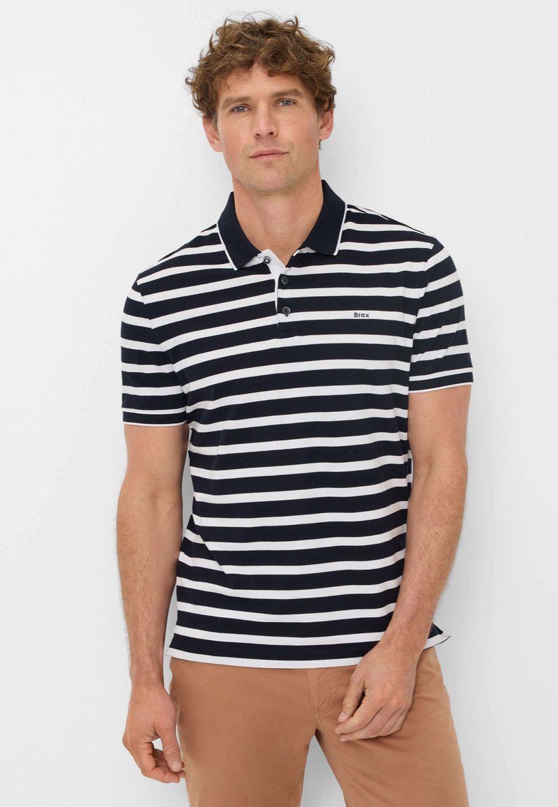 Navy and white striped polo shirt with a solid collar, three button placket, and a small logo on the chest, paired with tan pants.