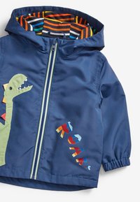 Giacca impermeabile navy con design di un dinosauro sul davanti, fodera a righe colorate e lettering geometrico vivace. Chiusura con cerniera e polsini elasticizzati.