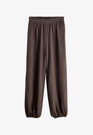 Pantalon ample, brun foncé texturé avec ceinture élastique et poignets élastiques, adapté pour un port décontracté ou relax.